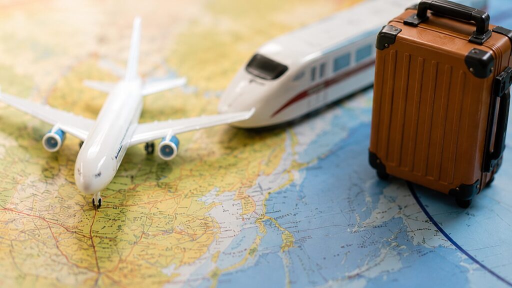 地図の上に飛行機や新幹線、スーツケースを配置した遠方ゲストの交通費イメージ