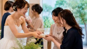 披露宴のお見送りで新婦がゲストへプチギフトを手渡している様子